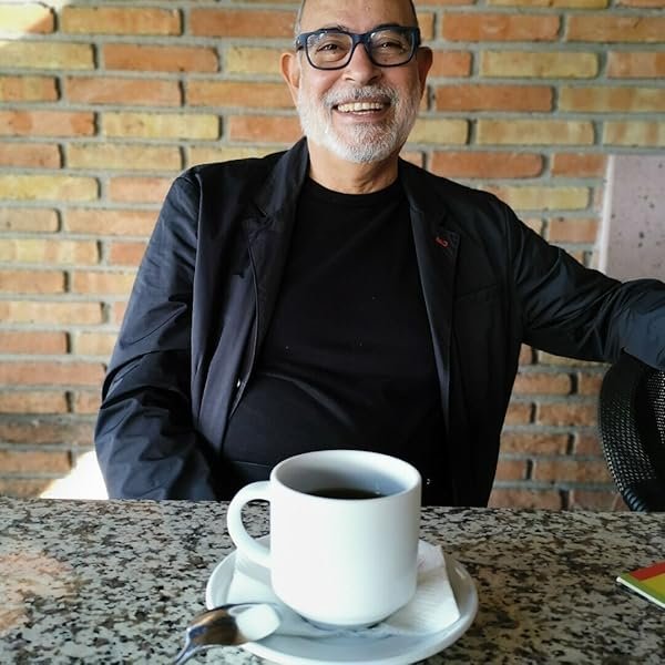imagen frontal de rodolfo h farías en la que aparece sonriente, delante suyo tiene una taza de café