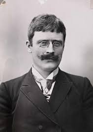 imagen frontal de un joven Knut Hamsun en la que aparece con gafas y bigote